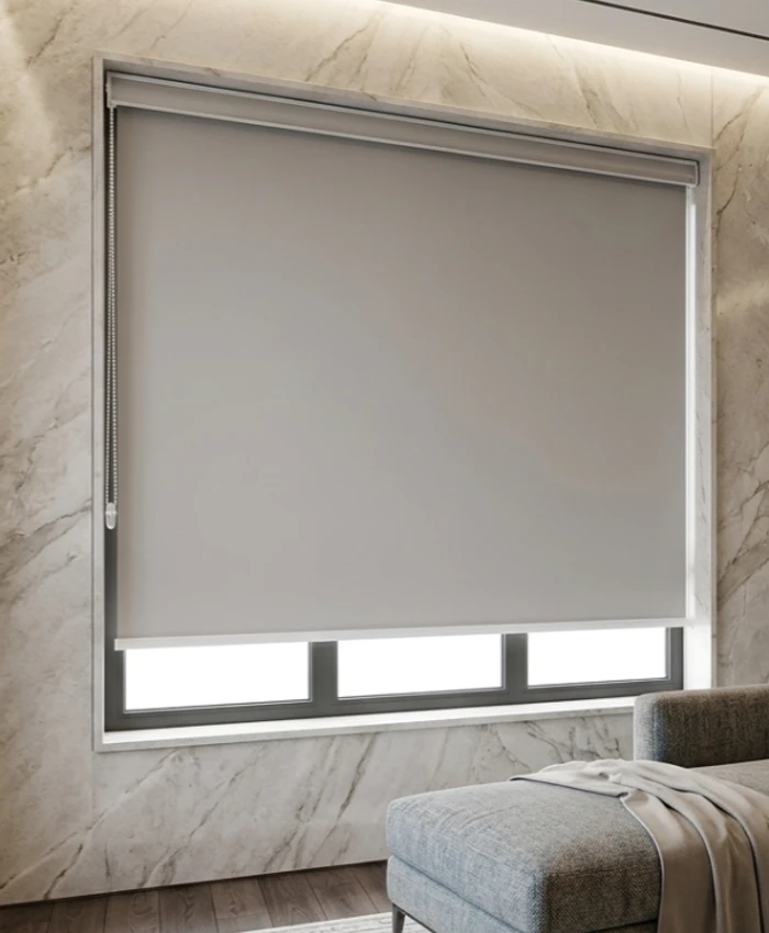 Architectural blackout roller blind with clean bottom bar against marble wall