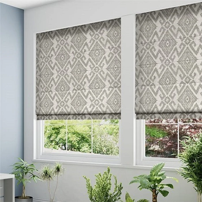 Tailored patterned Roman fabric blinds with geometric folds in sunlit room